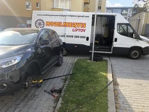Dodávka MOBILSERVIS LIPTOV pri zdvihnutom aute na sídlisku